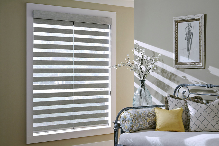 Find Versatile and stylish window blinds for Destin homes at Sunburst. Gray blinds on a large window next to a couch.