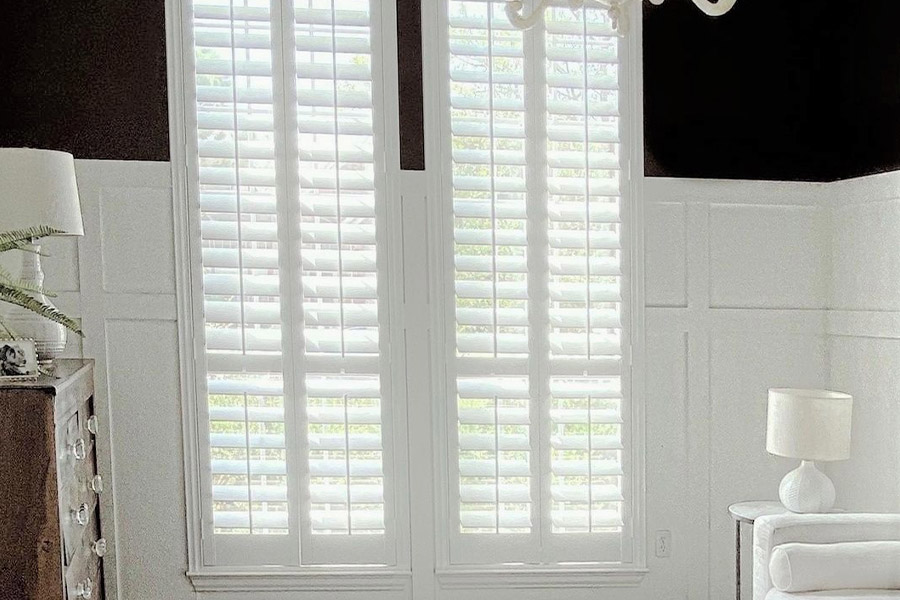 Polywood shutters give your long windows more energy efficiency. Photo Credit: @ nifty.nest White and black sleek living room with long white polywood shutters